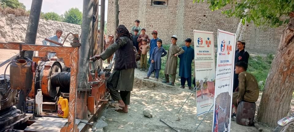 The village gathers as water is reached